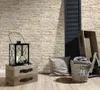 A still life arrangement of home decor items against a stone-effect wallpaper. Produktbild-Vorschau