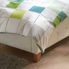 A close-up view of a bed with a patterned duvet cover. Produktbild-Vorschau