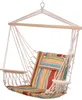 A hanging chair with a striped cushion and a small pillow, suspended by ropes from a wooden bar. Produktbild-Vorschau