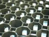 A close-up, angled view of a black plastic grid structure with hexagonal cells. Produktbild-Vorschau