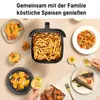 A table setting with various dishes, including french fries in an air fryer basket, shrimp, fish, and sweet potatoes, with drinks and dipping sauce. Produktbild-Vorschau