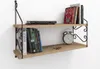 A two-tiered wooden shelf mounted on a white wall, displaying books, an alarm clock, and keys. Náhled obrázku produktu