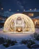 A geodesic dome tent set up in a snowy backyard at night, illuminated by string lights and a fire pit inside. Podgląd zdjęcia produktu