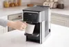A hand is placing a mug under a Philips hot water dispenser in a kitchen setting. Anteprima dell’immagine prodotto