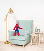 A Spider-Man plush toy sits on a light blue armchair, with a floor lamp to the left and two small side tables to the right. Podgląd zdjęcia produktu