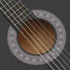 A close-up view of the soundhole and strings of a black acoustic guitar. Voir les images du produit