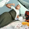 A man is waking up in a tent, stretching inside a sleeping bag. Náhľad obrázku produktu