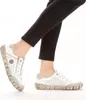 A person wearing black pants and white sneakers. Podgląd zdjęcia produktu