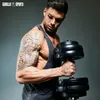 A muscular man with tattoos is holding a dumbbell, posing for a fitness brand. Náhled obrázku produktu