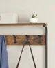 A close-up view of a coat rack with a shelf above, displaying a blue jacket and a brown bag hanging from hooks, with a potted plant and a decorative box on the shelf. Náhled obrázku produktu