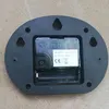 The back of a clock mechanism is shown, mounted on a black oval-shaped backing. Voir les images du produit