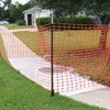 An orange plastic safety fence is set up around a concrete area in front of a house. Náhled obrázku produktu