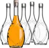 A group of five empty glass bottles, with one bottle in the foreground filled with amber liquid and a cork. Podgląd zdjęcia produktu
