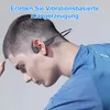A man wearing a blue shirt and bone conduction headphones, looking down. Produktbild-Vorschau