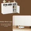 A white sideboard with doors and open shelves, decorated with vases and books. A second image shows the bottom of the sideboard with a robot vacuum cleaner underneath. Produktbild-Vorschau