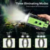 A hand holding a green and black emergency radio with a flashlight beam illuminating a forest scene. Produktbild-Vorschau