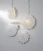 Four white paper star lanterns are hanging on a white wooden wall. Podgląd zdjęcia produktu