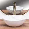 A close-up shot of a marble-patterned sink with a gold faucet, reflected in a mirror. Náhled obrázku produktu
