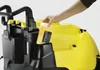 A person's hand is inserting a yellow liquid container into a yellow and black cleaning machine. Anteprima dell’immagine prodotto