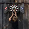 A young boy is playing darts against a wooden wall. Náhľad obrázku produktu