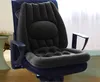 A black ergonomic cushion is placed on a blue office chair. The background shows a room with a window and curtains. Produktbild-Vorschau