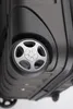 Close-up view of the bottom of a black suitcase, focusing on one of its wheels. Voir les images du produit