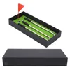 A golf pen set is displayed in a black box with a green felt interior, resembling a miniature golf course. A red flag and two white golf balls are also visible. Voir les images du produit