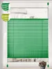 A green pleated blind is shown installed on a window. Produktbild-Vorschau