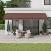 A brown retractable awning is installed above a patio door of a house, with outdoor furniture and plants visible. Produktbild-Vorschau