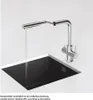 A chrome kitchen faucet with a pull-out spout is shown over a black sink, with water running. Podgląd zdjęcia produktu