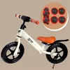 A balance bike for children with protective gear shown in a circular inset. Náhled obrázku produktu