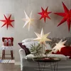 A cozy living room scene with Christmas decorations, featuring paper star lanterns. Produktbild-Vorschau