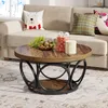 A round coffee table with a wooden top and black metal base, decorated with Christmas-themed items and pillows on a sofa in the background. Anteprima dell’immagine prodotto