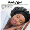 Schwarze Satin-Schlafhaube, getragen von einer schlafenden Frau auf einem gestreiften Kissen Anteprima dell’immagine prodotto