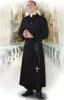 A man dressed as a priest stands in a church aisle, holding rosary beads. Produktbild-Vorschau