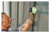A man is cleaning a window with a microfiber cloth. Podgląd zdjęcia produktu
