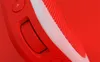 A close-up shot of a red portable Bluetooth speaker, focusing on the volume dial and a button. Produktbild-Vorschau