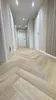 A hallway with herringbone flooring and doors. Produktbild-Vorschau