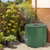 A green rain barrel is shown in a garden setting, collecting water from a downspout. Náhled obrázku produktu