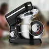 A black stand mixer with a stainless steel bowl is shown in a kitchen setting. Two close-up circles highlight the control knobs. Produktbild-Vorschau