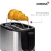 A close-up of a toaster with a croissant on top, highlighting its bun attachment feature. Produktbild-Vorschau