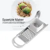 A spaetzle maker is shown next to a plate of food. Produktbild-Vorschau