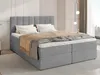 A grey upholstered boxspring bed with white bedding and a brown throw blanket is shown in a bedroom setting. Produktbild-Vorschau
