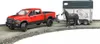 A red toy truck is towing a horse trailer with a toy horse inside. Produktbild-Vorschau