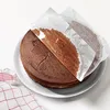 A chocolate cake with parchment paper being peeled off. Produktbild-Vorschau