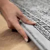 A close-up shot of a hand touching a rug. Produktbild-Vorschau