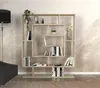 A modern, light wood bookshelf with an asymmetrical design, filled with books and decorative items, placed in a room with a textured wallpaper and a floor lamp.