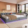 A bedroom scene featuring a large, modern bed with a tufted headboard and ambient lighting. Produktbild-Vorschau