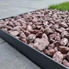 Rot-weiß gemaserte Kieselsteine als Flächenabdeckung mit metallischer Beeteinfassung Produktbild-Vorschau