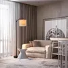 A cozy living room scene with a floor lamp, sofa, and artwork. Produktbild-Vorschau